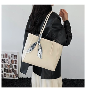 Detail of beige tote bag with litchi texture PU leather and blue France silk scarf
