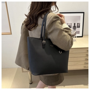 Dettaglio della borsa tote nera testurizzata con logo dorato e fibbia metallica regolabile