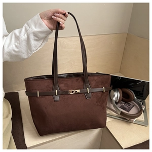 Détail du sac cabas en daim marron avec sangle en cuir et boucle métallique dorée