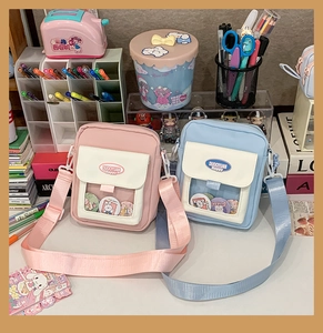 Détail de petits sacs bandoulière rose et bleu avec fenêtre transparente et badges