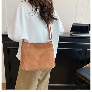 Brown corduroy shoulder bag with vertical stripes shown in a casual commuter setting