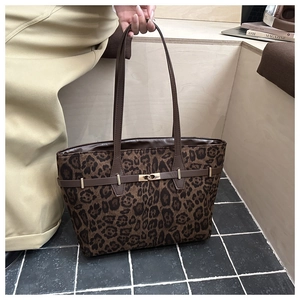 Détail du sac cabas léopard avec anses en cuir marron et fermoir tournant en métal doré