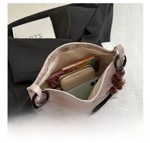 Internal capacity of pink embroidered handbag with wooden beads and magnetic closure