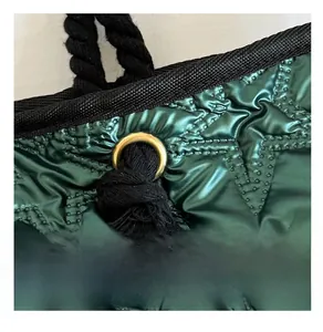 Détail du tissu en satin matelassé vert foncé avec motifs d'étoiles et œillets dorés