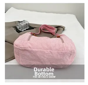 Detail view of the pink corduroy shoulder bag showing wear-resistant bottom with zippers
