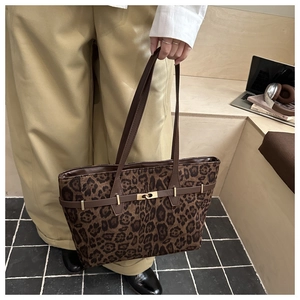 Détail du sac cabas en daim léopard avec brides marron et boucle en métal dorée