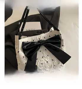 Detailed view of seersucker tote bag featuring black bow accents and polka dot pattern