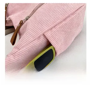 Detail of pink corduroy shoulder bag side pocket with green sunglasses storage