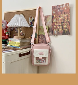 Détail du sac à bandoulière rose en toile avec fenêtre transparente et sangle réglable