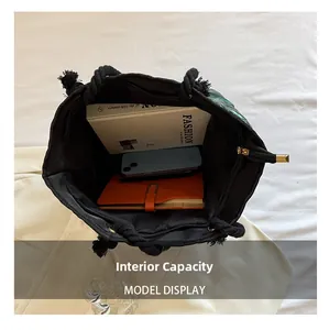 Vue macro de l'intérieur du grand cabas noir montrant des livres et un téléphone
