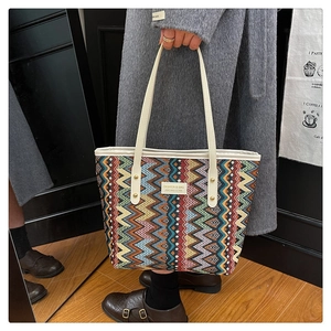 Detailed view of large ethnic tote bag with colorful geometric patterns and wide strap