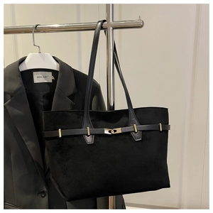 Détail du cabas en daim noir avec boucle dorée décorative et œillets métalliques