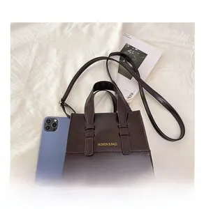 Compact brown waxed leather tote bag size comparison with a magazine and mobile phone