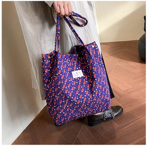 Gros plan détaillé d'un cabas floral violet en tissu gaufré avec étiquette de marque
