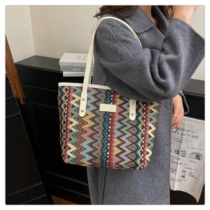 Detail of colorful ethnic weave tote bag with geometric wave pattern and white handle