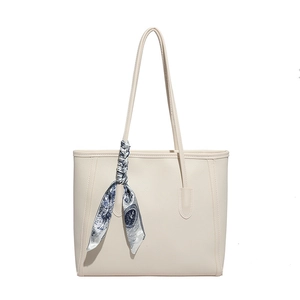 Chic beige tote bag with pebble leather texture and decorative blue floral scarf handle