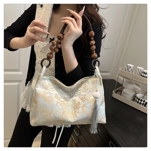 Detail of Chinese style embroidery bag featuring landscape pattern and wooden bead handle