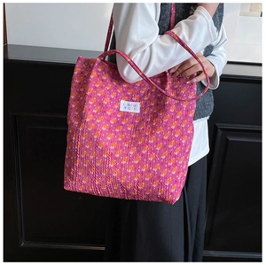 Détail de la texture d'un sac cabas floral en velours côtelé rose avec étiquette marque