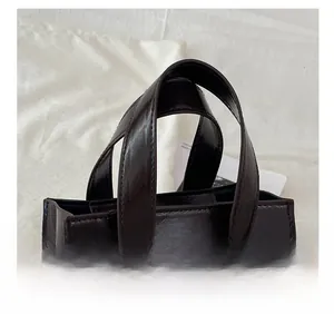 Detail showing the dual handles and high-gloss oil wax finish of the brown square handbag
