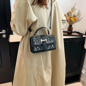 Détail du sac léopard avec fermoir en H doré et finitions en cuir noir élégant