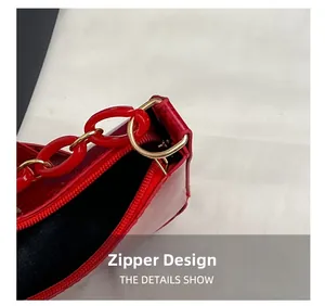 Detail of red faux snake pattern bag featuring gold hardware and a chunky chain strap