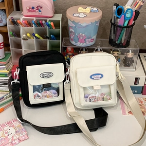 Détail de sacs bandoulière en toile noir et blanc avec poche transparente pour accessoires