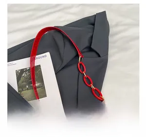 Close-up of red snake pattern texture and matching acrylic chain on women shoulder bag