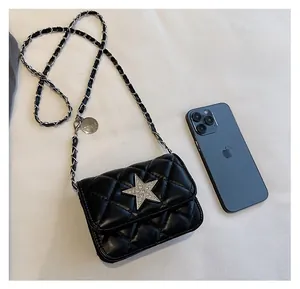 Size comparison of black quilted crossbody bag with star decor and smartphone