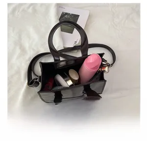 Spacious interior of dark brown oil wax leather handbag holding cosmetics and skincare