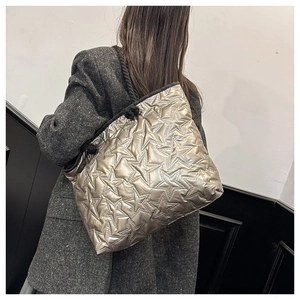 Détail du sac cabas argenté matelassé avec motif d'étoiles et poignées en corde noire