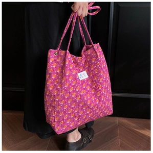 Gros plan détaillé du sac cabas floral rose avec tissu plissé et bouton-pression métal