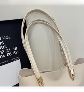 Close-up of minimalist tote bag straps with gold hardware and high-quality stitching