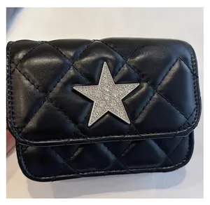 Detail of black quilted leather mini bag featuring a large silver star with rhinestones