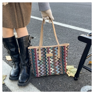 Close-up of bohemian tote bag with colorful chevron patterns and brown leather handles