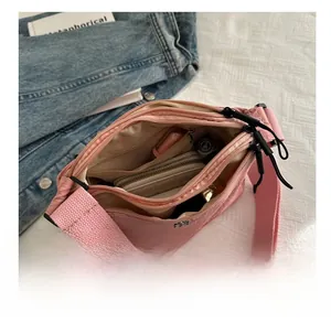 Sac bandoulière rose à plusieurs compartiments avec large sangle et rangement