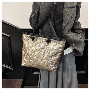 Détail du sac cabas doré champagne avec motifs étoiles matelassés et poignées cordes