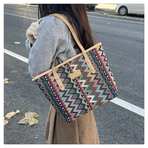 Detail of colorful geometric wave pattern knit tote bag with premium leather shoulder strap