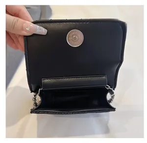 Detail view of the black crossbody bag showing its interior space and silver magnetic closure