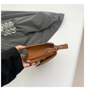 Vue détaillée du sac en similicuir marron avec boucle dorée et coutures précises