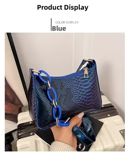Detail view of blue snakeskin pattern texture and blue acrylic chain on the shoulder bag