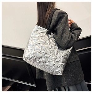 Détail du sac fourre-tout argenté avec matelassage en étoile et bandoulières tressées noires