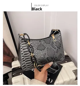 Close-up of black snakeskin texture underarm bag with gold chain strap detail
