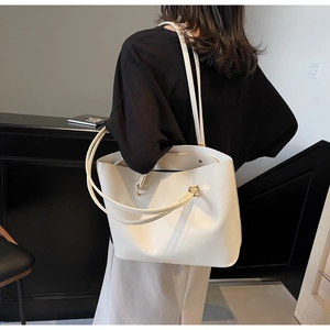 Detailed back view of a minimalist white leather tote bag shown on a model for scale