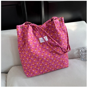 Détail du sac cabas rose à fleurs montrant le tissu plissé 3D et l'étiquette tissée