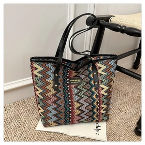 Detail of ethnic striped woven tote bag with colorful wave patterns and a fashion brand label