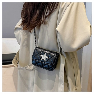 Close-up of black quilted leather mini bag with silver rhinestone star and chain strap