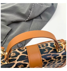 Gros plan du sac à main léopard avec bandoulière en cuir marron et boucles dorées