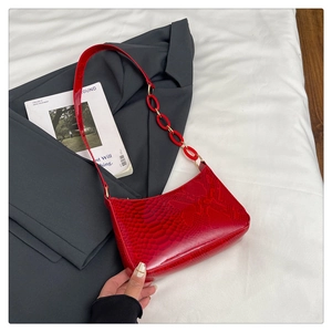 Detailed view of red snakeskin embossed hobo bag with trendy red plastic chain strap