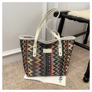 Close-up of a large bohemian tote bag with colorful chevron patterns and leather handles