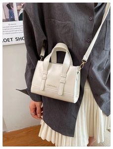 Detail view of cream oil-wax leather handbag styled with a shoulder strap for a vintage look